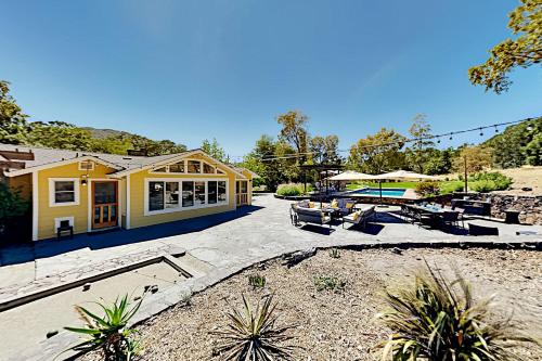 a yellow house with a patio and a pool at Warm Springs Paradise in Glen Ellen
