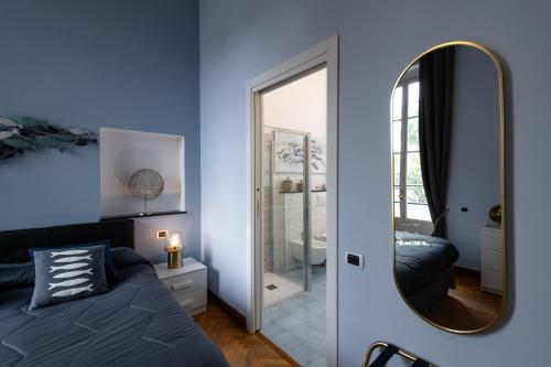 a blue bedroom with a bed and a mirror at Casa Garibalda - seafronf apartment in Rapallo