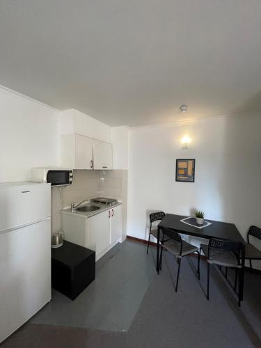 a kitchen and dining room with a table and chairs at Juiceven Studios in Alcabideche