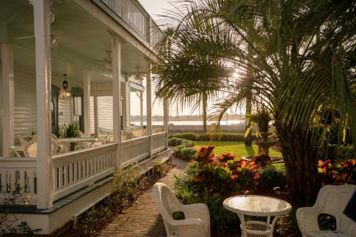 um alpendre de uma casa com cadeiras e uma mesa em Bayfront Westcott House Bed & Breakfast em St. Augustine