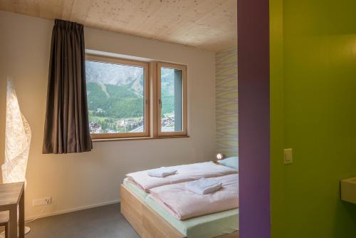 um quarto com uma cama e uma janela em wellnessHostel4000 em Saas-Fee