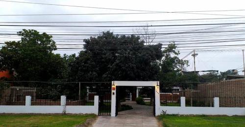 ein Tor, das in einen Garten mit einem Zaun führt in der Unterkunft Montemira Private House in Ica