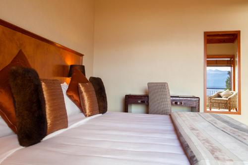 Fiordland Lodge في تي أناو: غرفة نوم مع سرير وإطلالة على المحيط