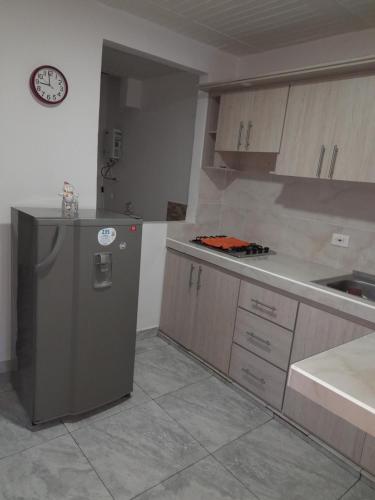 a kitchen with a refrigerator and a counter and a clock at APARTAMENTO FAMILIAR MARAL 2 in Salento