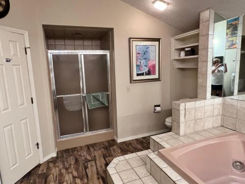 uma casa de banho com um chuveiro, uma banheira e um lavatório. em Golfside Vacation Home 1 em Bella Vista