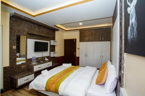 a bedroom with a large bed and a television at Gauri Shankar Hotel Nagarkot in Nagarkot