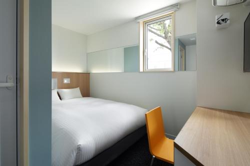 ein kleines Schlafzimmer mit einem Bett und einem Fenster in der Unterkunft Kamishihoro Hotel in Kami-shihoro