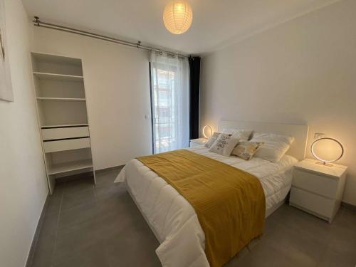 une chambre avec un grand lit et deux lampes dans l'établissement Appartement climatisé 4 couchages avec terrasse et parking sécurisé à Antibes, proche port et mer - FR-1-252-180, à Antibes