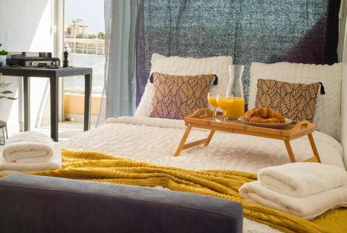 a bed with a tray of food and orange juice at Port de Carnon/Plage Studio Cabine COsy in Mauguio