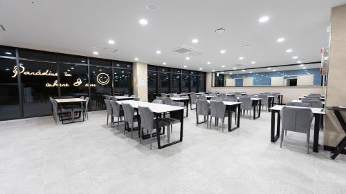 a dining room with tables and chairs in a restaurant at Primula Hotel - Formerly Sanbangsan Hotel in Seogwipo