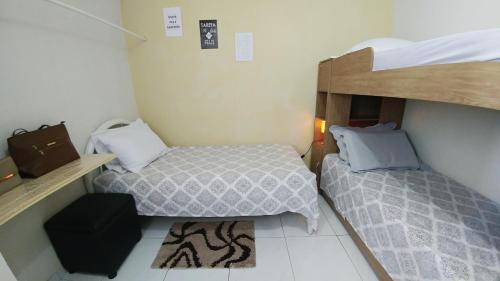 Una cama o camas en una habitación de Quarto Individual para 3 Pessoas em AP Compartilhado