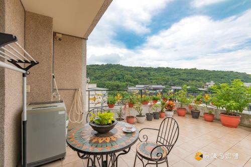 a patio with a table and chairs on a balcony at Happiness is coming(Near Hualien Railway Station) in Hualien City