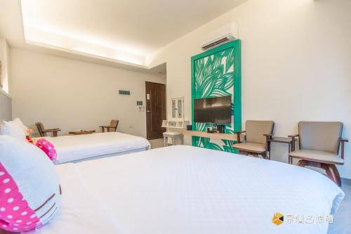 a hotel room with two beds and a tv at 幸福來了-近花蓮火車站 寵物友善 電梯民宿 in Hualien City