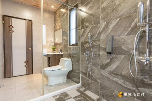 a bathroom with a toilet and a shower at 幸福來了-近花蓮火車站 寵物友善 電梯民宿 in Hualien City