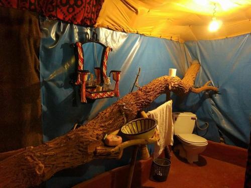 a bathroom with a bed made out of a tree branch at Tamaris Camp in Hassilabied