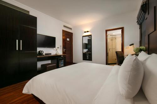 a bedroom with a large white bed and a desk at La Nueva Boutique Hotel Hanoi & Spa in Hanoi