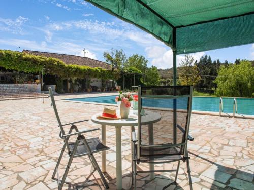 a table with a cake and two chairs next to a pool at Country Farmhouse in Montemor o Novo with Swimming Pool in Montemor-o-Novo