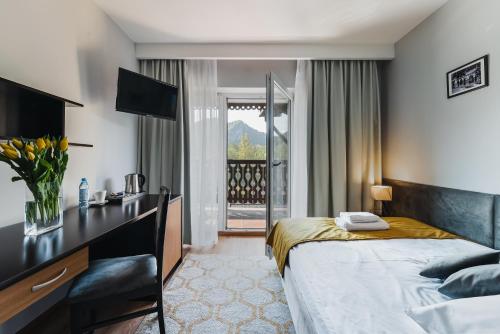 a hotel room with a bed and a desk at Hotel Smile Pieniny in Szczawnica
