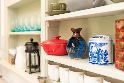 a shelf filled with blue and white vases and cups at Arcadia Lodge Russell in Russell