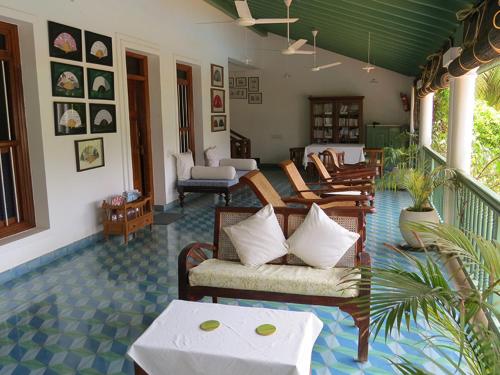 a living room with couches and chairs on a porch at The Bangala Chettinad in Kāraikkudi