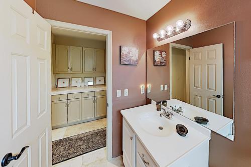 een badkamer met een wastafel en een spiegel bij Calle Quito Escape Permit# 217,228 in La Quinta