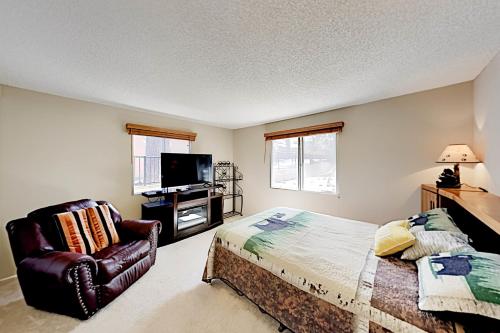 1 dormitorio con 1 cama, 1 silla y TV en Meadow-Front Metcalf Bay Gem, en Big Bear Lake