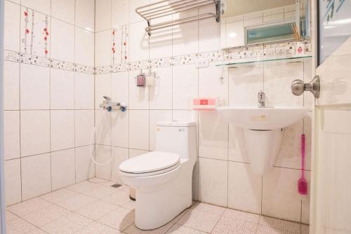 a white bathroom with a toilet and a sink at Xiaoliuqiu Happy House B&B in Xiaoliuqiu