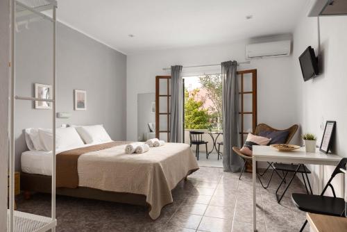 a bedroom with a bed and a table and a chair at Marias Seaside Apartments in Acharavi
