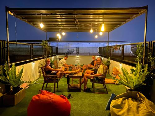 a group of people sitting on a patio at night at Backpack Hostel in Chiang Rai