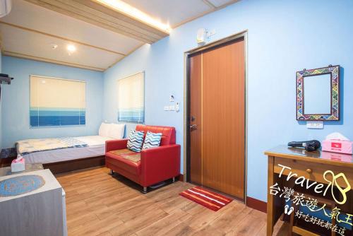 a hotel room with a bed and a red chair at Xiaoliuqiu Happy House B&B in Xiaoliuqiu