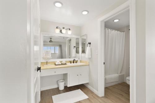 a white bathroom with a sink and a mirror at Bayside Walk Escape Unit A in San Diego