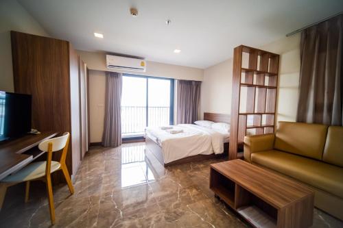 a hotel room with a bed and a couch at Rangsit Residence in Ban Talat Rangsit