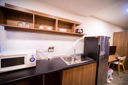 a kitchen with a sink and a microwave at Rangsit Residence in Ban Talat Rangsit