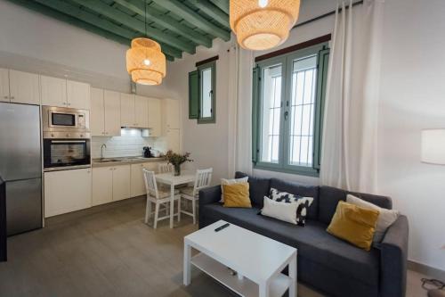 salon z niebieską kanapą i kuchnią w obiekcie One&lux Gran Poder - Cozy twin bedroom central Apartment w Sewilli