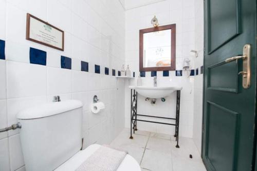 a bathroom with a white toilet and a sink at Ntouana hotel in Kalamata