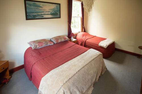 a hotel room with two beds and a window at Greenstone Retreat in Kumara