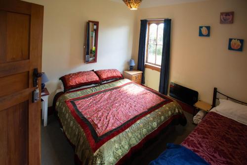 a bedroom with a large bed and a window at Greenstone Retreat in Kumara