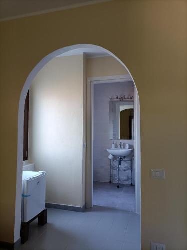 a white bathroom with a sink and a mirror at B&B Il melograno in Capoterra