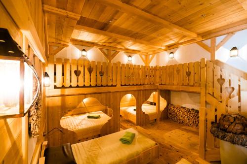 a room with two bunk beds and a wooden ceiling at Berghotel in Racines