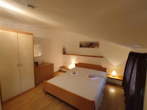 a bedroom with a bed with two paper plates on it at Apartmani Danica in Risika