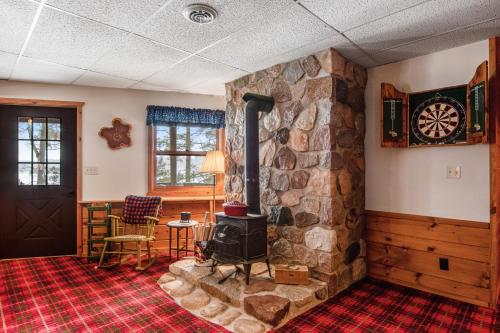 a living room with a stone fireplace and a stove at Sailor's Point Lodge in Eagle River