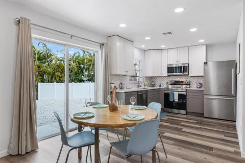 eine Küche mit einem Holztisch und Stühlen sowie einem großen Fenster in der Unterkunft Beach and Boaters Delight! in Fort Myers Beach