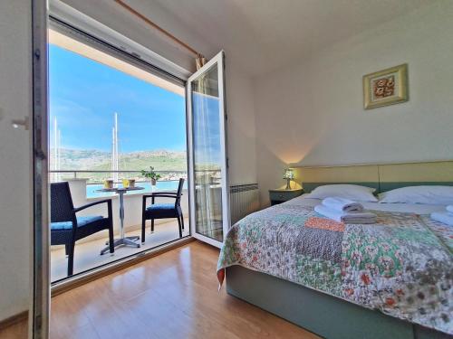 a bedroom with a bed and a balcony with a table and chairs at Rooms and Apartments Porat in Split