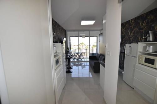 Il comprend un salon et une cuisine équipée d'appareils électroménagers blancs. dans l'établissement Studio Naturiste 