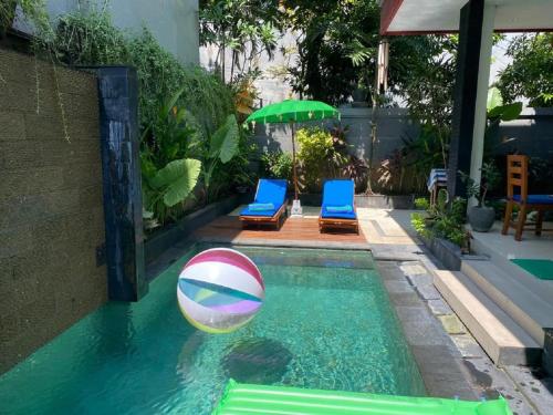 a swimming pool with a beach ball in the water at Villa Tenang Legian in Legian