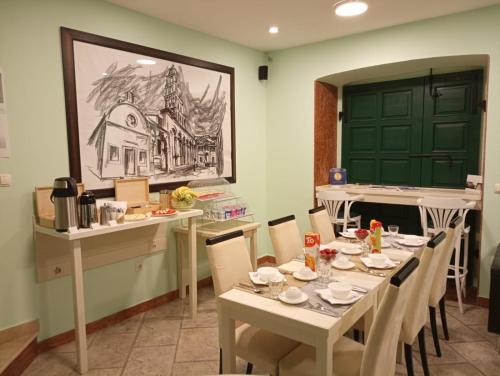 uma sala de jantar com uma mesa com cadeiras e uma porta verde em Rooms Toni Palace em Split