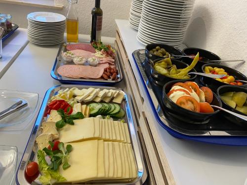a buffet with three trays of food on a table at Hotel Brückentor in Rinteln
