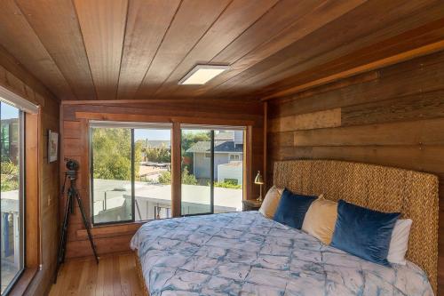 a bedroom with a bed and a large window at Calle Paradise in Stinson Beach