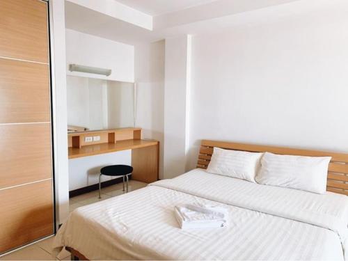 a bedroom with a white bed and a desk at Rangsit Apartment II in Ban Talat Rangsit