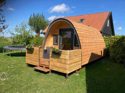 een klein houten huis in het gras bij Vakantiehuisjes Marsherne in Poppingawier